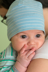 Baby with a cap enjoying on mothers shoulder © nedomacki