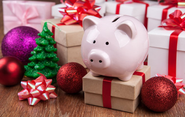 pink piggy bank with gift boxes and Christmas toys close up