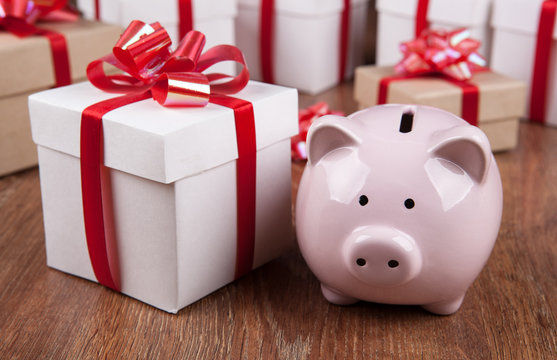 pink piggy bank with gift boxes with red bows