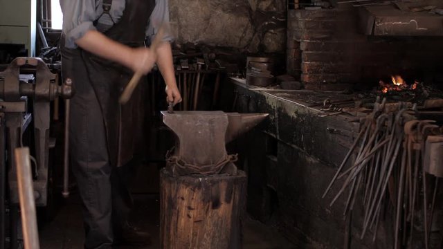 An old fashioned blacksmith craftsman using traditional 1800's techniques and hand tools.