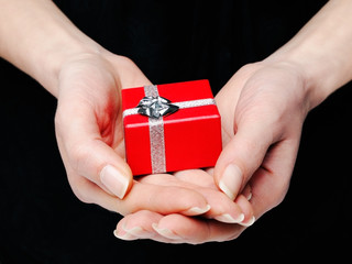 Hands holding a red gift box
