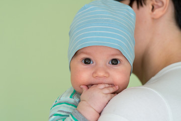 Baby with a cap enjoying on mothers shoulder © nedomacki