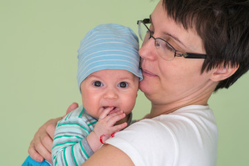 Baby with a cap enjoying on mothers shoulder