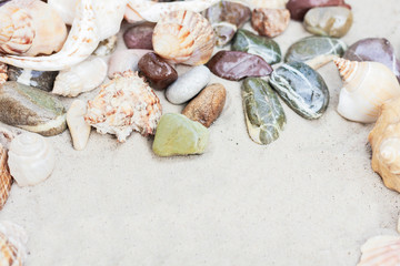 Summer background with copy space for text - seashells and colorful pebbles on the sand, beach in Thailand 