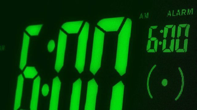 Digital alarm clock waking up at 6 AM. Close-up LED display. The numbers on the clock screen changes from 5:59 no 6:00 AM. Then alarm logo appears on the screen. 3D rendering animation.