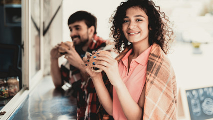 Young Couple in Checkered Plaids Eating Burgers.