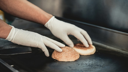 Close up. Worker Cooking Burger in Food Truck.