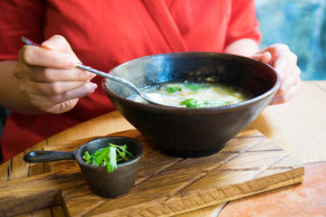 Woman eating Georgian Mutton Soup in restaurant.