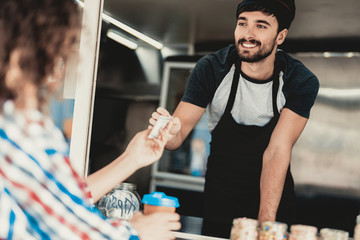 Young Woman in Shirt Buying Coffee in Food Truck.