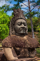 Fototapeta na wymiar Stone carved statue Asura as guardian on right side bridge of South gate of Angkor Thom near Bayon temple in Siem Reap, Cambodia. Popular tourist attraction