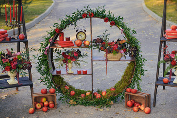 set of autumn wedding decor outdoors. Floral arrangement of flowers and fruits details of the...