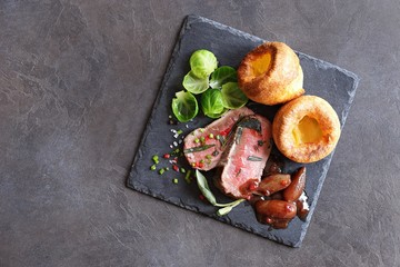 
    Roast beef with yorkshire pudding, brussels sprouts and shallots. Traditional british roast beef. Overhead view