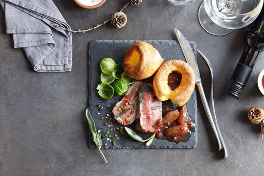 
    Roast beef with yorkshire pudding, brussels sprouts and shallots. Traditional british roast beef. Overhead view 