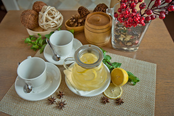 tea with a lemon in a glass service on a wooden table