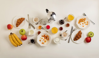 Breakfast time. Croissants and orange juice, jam and honey. Coffee with cream or milk. Fruits - bananas, red and green apples. Ricotta with sour cream, nuts and dried apricots. 