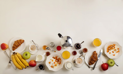 Breakfast time. Croissants and orange juice, jam and honey. Coffee with cream or milk. Fruits - bananas, red and green apples. Ricotta with sour cream, nuts and dried apricots. 
