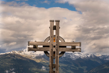 Summit cross with clouds over the Zillertal in Austria