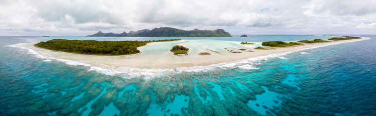 Aerial view of Raivavae island with beaches, coral reef and motu in azure turquoise blue lagoon....