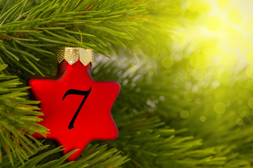 ein Weihnachtsbaumanh&auml;nger (Stern) am Baum mit einer Zahl (7)