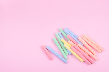 Colorful chalks on pink background 