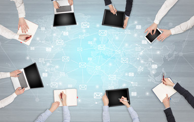 Group of people with devices in hands working in team on tablets, laptops with application concept
