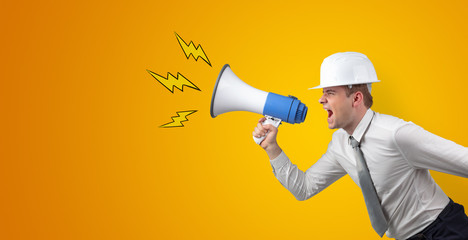 Fototapeta premium Young architect constructor yelling with megaphone and copyspace