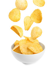 Bowl of tasty ridged potato chips on white background