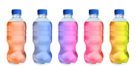 Set with different bottles of colorful drinks on white background