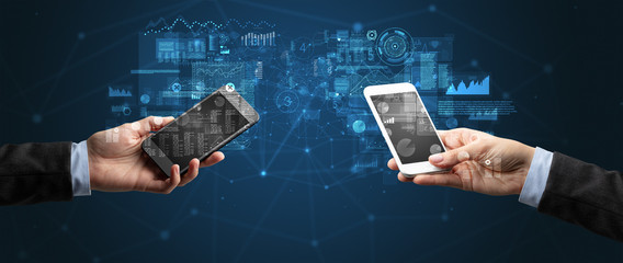 Close up of two hands holding smartphones to sync business data