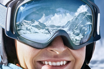 Portrait of man at the ski resort on the background of mountains and blue sky.A mountain range...