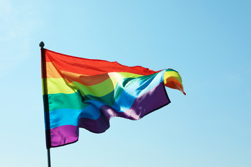 Rainbow gay flag against blue sky. LGBT concept