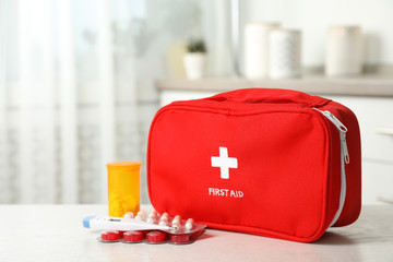First aid kit with pills on table indoors. Space for text