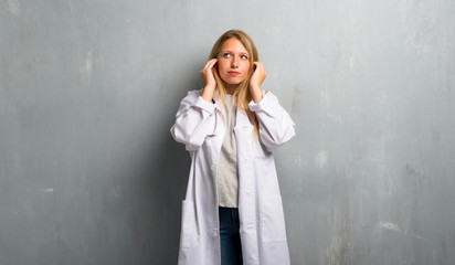 Young doctor woman covering ears with hands. Frustrated expression