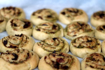 Savory pesto rolls made with spelt flour. Pesto is made with baby cabbage, parmesan cheese, garlic, almonds, sun dried tomatoes and olive oil. Selective focus.