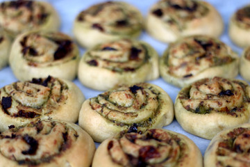 Savory pesto rolls made with spelt flour. Pesto is made with baby cabbage, parmesan cheese, garlic, almonds, sun dried tomatoes and olive oil. Selective focus.