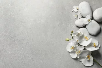 Papier Peint photo Lavable Orchidée Composition à plat avec pierres de spa et fleurs d& 39 orchidées sur fond gris. Espace pour le texte