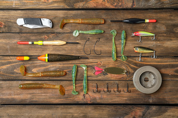 Flat lay composition with fishing equipment on wooden background