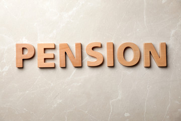 Word "PENSION" made of wooden letters on gray background