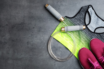 Flat lay composition with jump rope, gym equipment and space for text on grey background