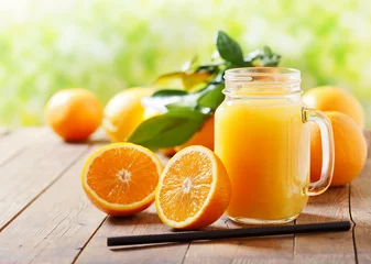Tuinposter glass jar of fresh orange juice with fresh fruits © Nitr