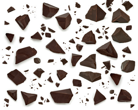 Broken, cracked or crushed dark chocolate parts from top view isolated on white background
