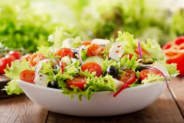 Gordijnen bowl of fresh salad with vegetables and greens © Nitr