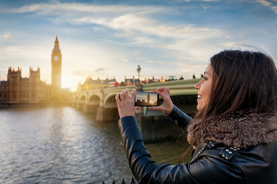 Attraktive Touristin in London fotografiert den Big Ben und Westminster Palast mit ihrem Handy bei Sonnenuntergang