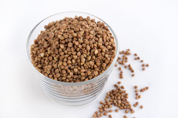 Buckwheat groats in a glass on white background
