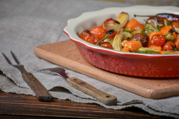 High Angle View Colorful Grilled Vegetables and pumpkin Served on Cast ceramic Pan and Resting on Wooden Table Surface with Copy Space.