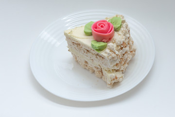 piece of meringue cake decorated with a rose on a plate