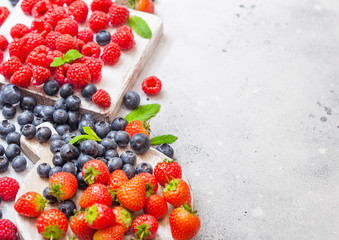 Fresh raw organic berries on vintage chopping boards on kitchen table background. Space for text....
