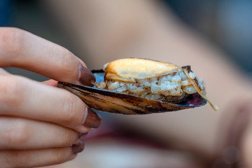 Woman eating seafood in a restaurant. Steamed mussels in white wine sauce. Food Concept