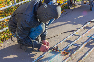 welder working on the street making a hedge