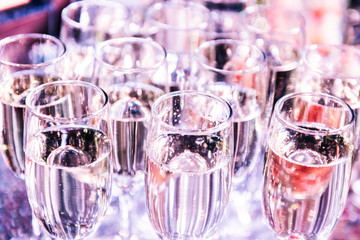 Celebration. Champagne glasses on the buffet table with snacks. Softly tinted, selective focus.